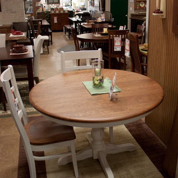 solid cherry 48 inch round dining table with painted ladder backed chairs at fireside with more of our selection behind
